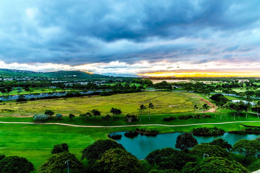 sunrise over the horizon with sun peeking under dark morning clouds at the resort community of ko olina on the island of oahu in the island state of hawaii